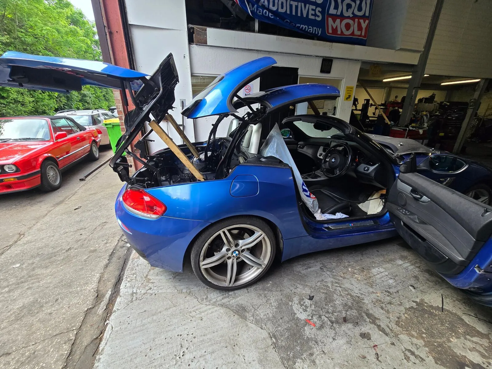 A BMW Z4 E89 with its roof mid-repair outside The Zed Shed