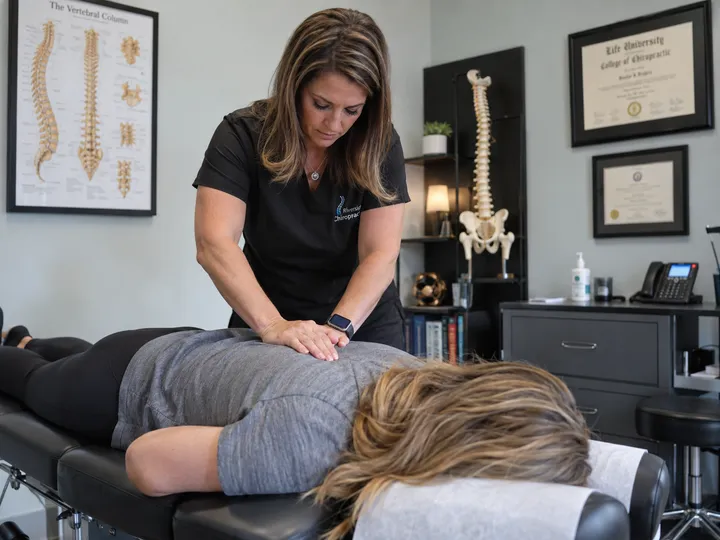 Chiropractor focused on patient treatment while AI handles incoming calls