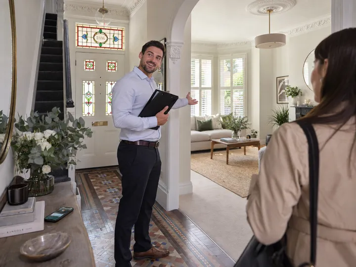 Real estate agent conducting viewing while AI receptionist handles vendor call
