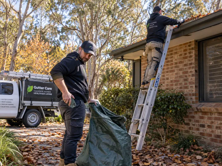 Busy gutter cleaning team in autumn while AI handles overflow calls