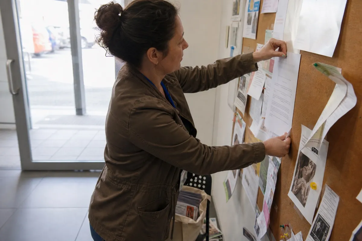 A home care agency manager pinning a printed one-page leaflet to a community noticeboard to build local referrals