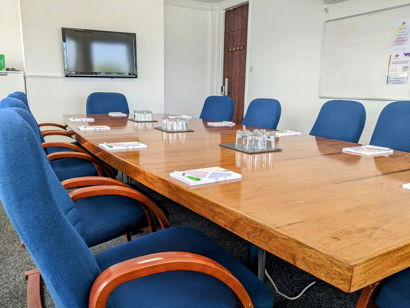 A meeting room at Waffle21 with a wooden table and blue chairs