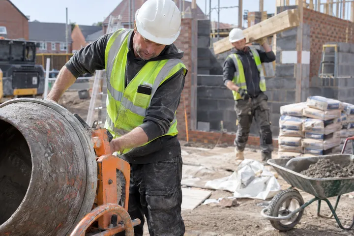 Contractor framing walls while AI handles incoming phone call