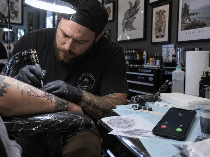 Tattoo artist unable to answer phone during tattooing session